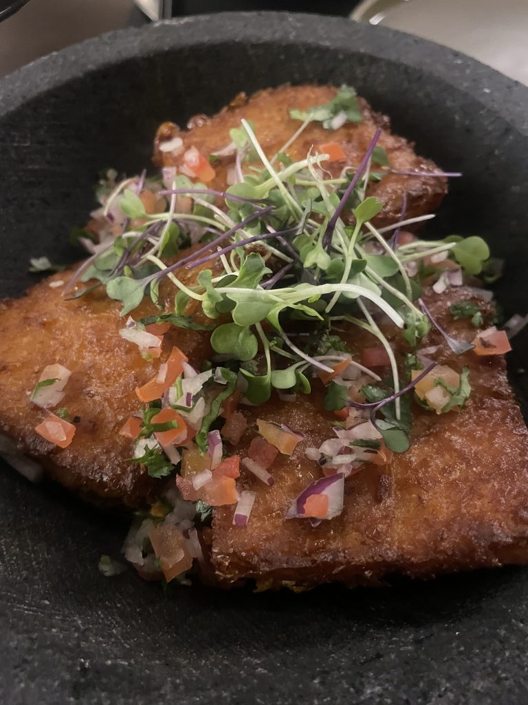 achiote-braised chicken served on sweetcorn cakes with pico de gallo and coriander at MANAW Restaurant Valencia